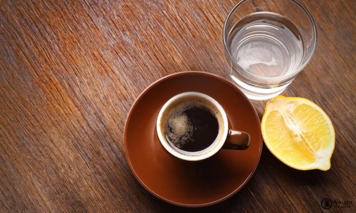 Cup of Coffee with Lemon and Water on Table