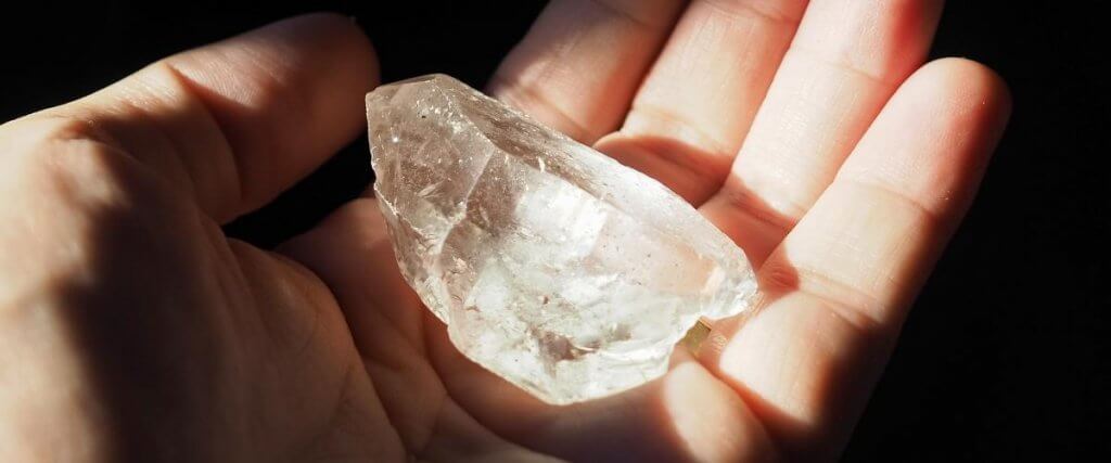 holding Clear Quartz crystal in hand