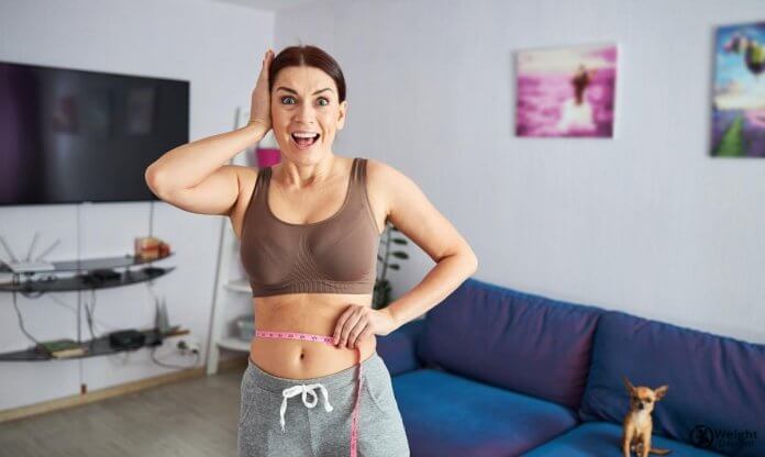 Happy female rejoicing at losing weight at home